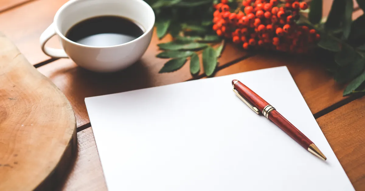 How to start a journaling habit — a simple notebook and pen on a clean desk beside a cup of coffee, representing the low-barrier start of a daily writing routine.